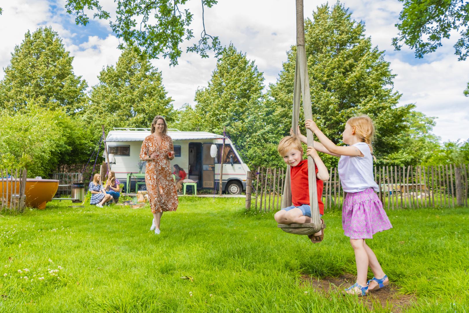Caravan met gezin en spelende kinderen